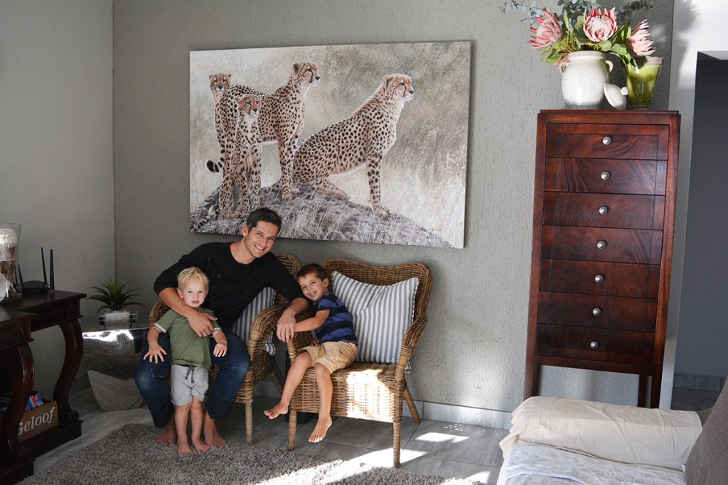 Danie Marais with his children and the painting Hunting g for hope