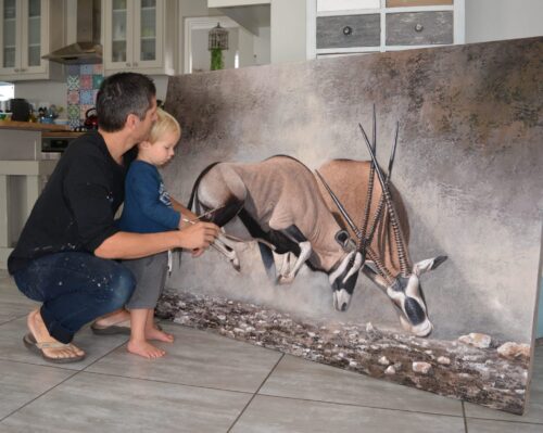 Danie Marais with his son Luka and the painting Clashing of horns