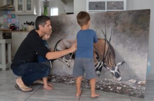 Danie Marais with his sons Karlo and Luka and the painting Clashing of horns