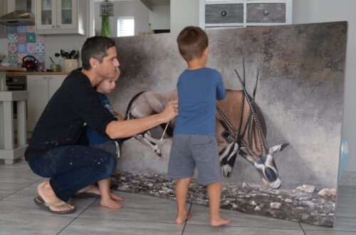 Danie Marais with his sons Karlo and Luka and the painting Clashing of horns