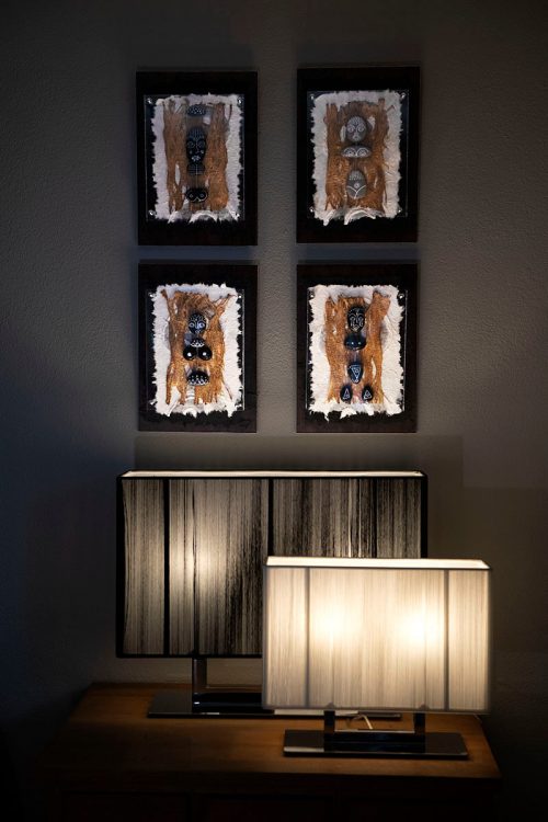 Pebble figures quartet on wall above lamps