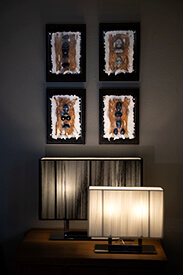 Decoratieve kunst met vier Kiezelsteen figuur stukken op wand boven schemerlamp